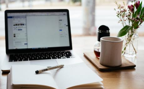 laptop with planner and mug on table