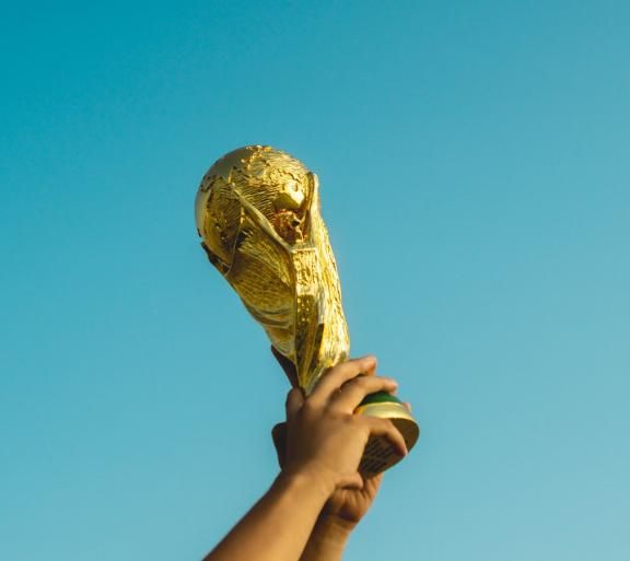 person holding gold figurine