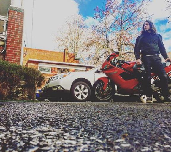 man standing in front of motorbike