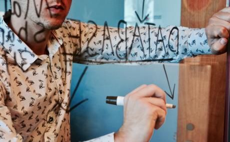 man writing on whiteboard