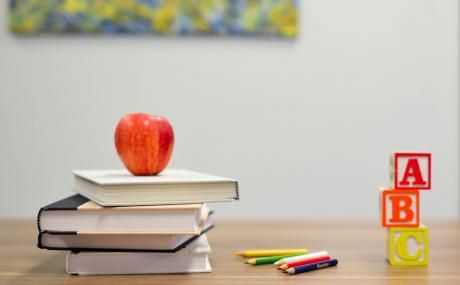 apple on stack of books on a desk