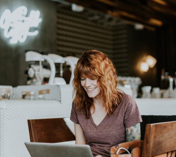 red haired woman typing on laptop