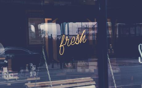 neon sign in window that reads "fresh"